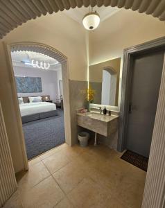 a bathroom with a sink and a bed in a room at استيديو حياة الفيصلية دخول وخدمة ذاتيه in Al Rass