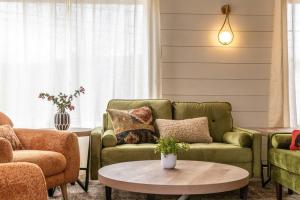 a living room with a couch and a table at 100% Renovated Stowe Village Farmhouse in Stowe +30 photos