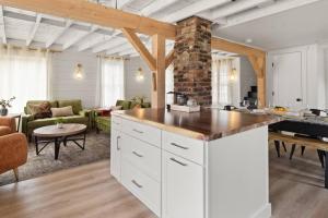 a kitchen with white cabinets and a living room at 100% Renovated Stowe Village Farmhouse in Stowe