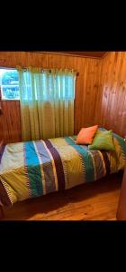 una cama con un edredón colorido en una habitación en Casa a 4 cuadras del centro de Pucon en Pucón