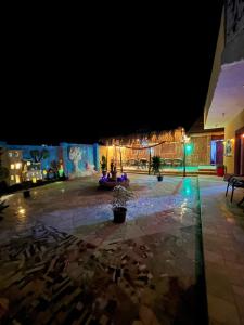 Oasis Camp في الباويطي: فناء في الليل مع أضواء في مبنى