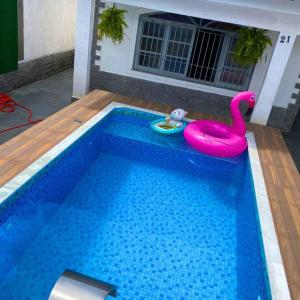 uma piscina com um cisne rosa e um brinquedo em Recanto Caiçara em Solemar
