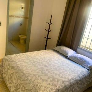 SolemarにあるRecanto Caiçaraのベッドルーム1室(ベッド1台付)、バスルーム(トイレ付)
