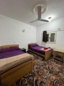 um quarto com 2 camas e uma ventoinha de tecto em Oasis Camp em Bawati