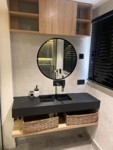 a bathroom with a black sink and a mirror at Spacious 2-Bedroom Mediterranean-Inspired Home in Ikeja