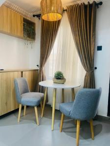 a table and two chairs in front of a window at Spacious 2-Bedroom Mediterranean-Inspired Home in Ikeja