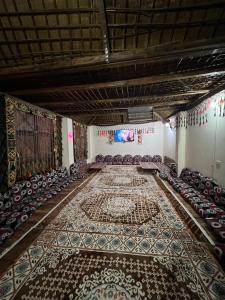an empty room with chairs and a persian rug at Oasis Camp in Bawiti