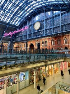 a large building with a clock on the ceiling at London Central Budget Rooms in London