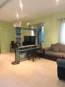 a living room with a television and a couch at Brown Gate House in Panabo