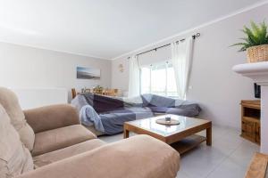 a living room with a couch and a table at 3 bedroom villa, 10min walk to shops, bars & beach in Luz