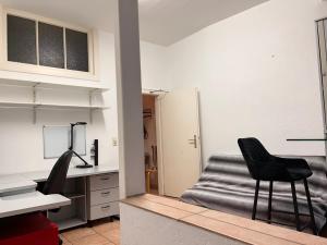 una oficina con escritorio y 2 sillas negras en Hotel Apartment, en Colonia