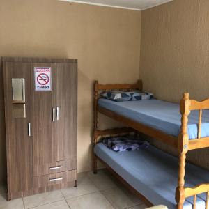 Pokój z 2 łóżkami piętrowymi i szafką w obiekcie Pousada Patriarca Silva w mieście Rio Grande