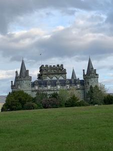 an old castle with towers on top of a field at Arkland in Inveraray