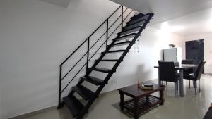 uma escada em espiral numa sala de estar com uma mesa em Depto Lionel em Río Gallegos