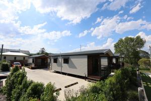 uma pequena caravana branca estacionada num parque de estacionamento em Kenilworth Country Cabins em Kenilworth