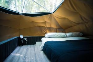 een slaapkamer met een bed in een tent bij Domos Paseo Nativo in Chillán