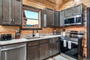 uma cozinha com utensílios de aço inoxidável e uma janela em Cozy Family Cabin w/ Hot Tub in Sevierville em Sevierville