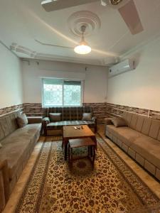 Sala de estar con 2 sofás y mesa de centro en Andalius1, en Irbid