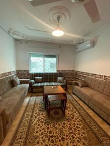 Sala de estar con sofás y mesa de centro en Andalius1, en Irbid