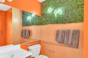 pomarańczowa łazienka z toaletą i lustrem w obiekcie Color Splash Pad!! w mieście Arlington