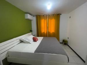 een bed in een kamer met groene en gele muren bij Villa Quenette au François in Le François