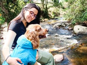una mujer sosteniendo un perro en su espalda en un arroyo en Tierra Maravilla en Salento