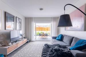 ein Wohnzimmer mit einem Sofa und einem TV in der Unterkunft Balmain Designer 1 Bedroom Apartment with Parking in Sydney
