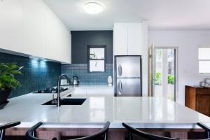 a kitchen with a sink and a refrigerator at Balmain Designer 1 Bedroom Apartment with Parking in Sydney