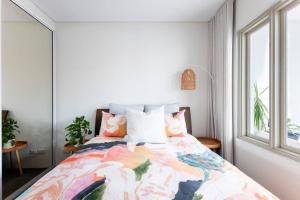 1 dormitorio con 1 cama con un edredón colorido en Balmain Designer 1 Bedroom Apartment with Parking, en Sídney
