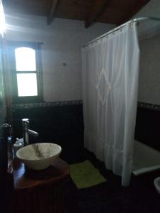 a bathroom with a sink and a shower curtain at Cabaña Lemu Unku, El Pinar -6 personas- in La Lucila del Mar