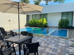 a child playing in a swimming pool with an umbrella at Casa Campestre para Descansar Girardot in Flandes