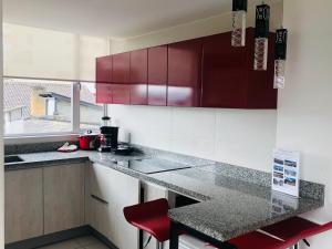 a kitchen with red cabinets and a counter top at Exclusivo alojamiento, excelente vista y ubicación in Quito