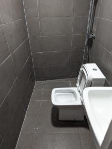a bathroom with a white toilet and a sink at Mile End Rooms in London