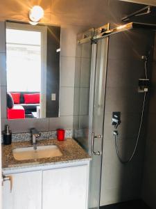 a bathroom with a sink and a shower with a mirror at Exclusivo alojamiento, excelente vista y ubicación in Quito