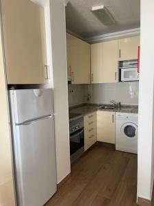 a kitchen with white cabinets and a washer and dryer at Casa do Leme in Armação de Pêra