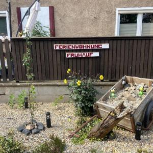 un jardín con una valla de madera y un cartel en Ferienwohnung 'Frühauf' im Südharz OT Uftrungen 