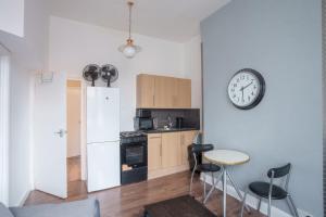 a kitchen with a table and a clock on the wall at Central London Stay in London