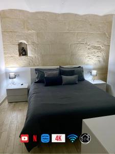 1 dormitorio con 1 cama negra grande y 2 mesas en SASSARI-CENTRO Elegante Appartamento con WiFi e Netflix, en Sassari