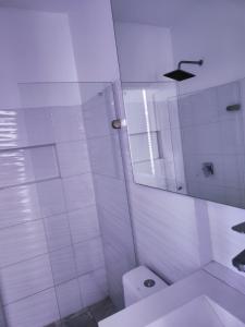 a white bathroom with a toilet and a mirror at Apto 2Habs 2baños Hermosa vista in Cartagena de Indias