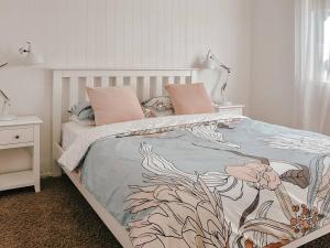 a bedroom with a bed with a floral bedspread at Prime Beachfront Retreat in Hokitika