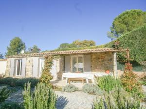 ein Steinhaus mit einem Tisch im Garten in der Unterkunft Villa des Arts in Draguignan