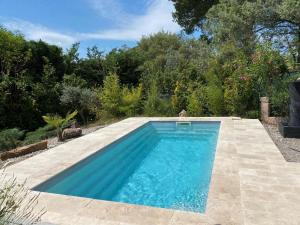 einen Pool inmitten eines Gartens in der Unterkunft Villa des Arts in Draguignan