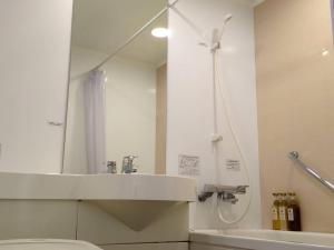 ein Bad mit einem Waschbecken, einer Dusche und einem WC in der Unterkunft Hotel Alpha-One Himeji Minamiguchi in Himeji