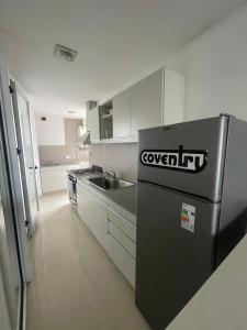 eine Küche mit einem schwarzen Kühlschrank und einer Spüle in der Unterkunft Alquiler Temporario 3 Ambientes in Lincoln