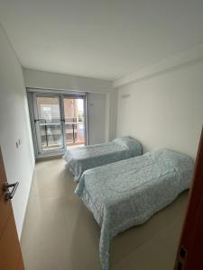 2 Betten in einem Zimmer mit Fenster in der Unterkunft Alquiler Temporario 3 Ambientes in Lincoln