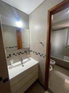 ein Badezimmer mit einem Waschbecken, einem WC und einem Spiegel in der Unterkunft Alquiler Temporario 3 Ambientes in Lincoln