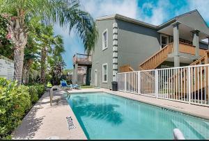 a house with a swimming pool in front of a house at The Waves #A1 in South Padre Island