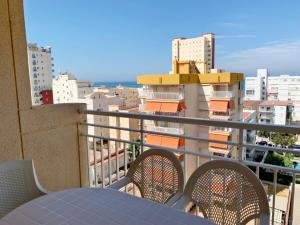 - Balcón con mesa, sillas y edificios en MIAMI Playa de Gandía - Alquiler solo familias en Playa de Gandia