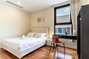 Un dormitorio con una cama y un escritorio y una ventana. en DeLux Best Central D1,3Bedrooms,2 Bath,Pool,Gym, en Ho Chi Minh 26 fotos más