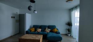 a blue couch in a living room with a table at Apartamento El dragoncillo del Cabo in Las Negras